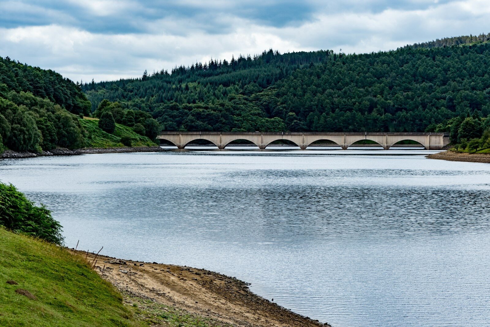 A large body of water with a bridge in the background